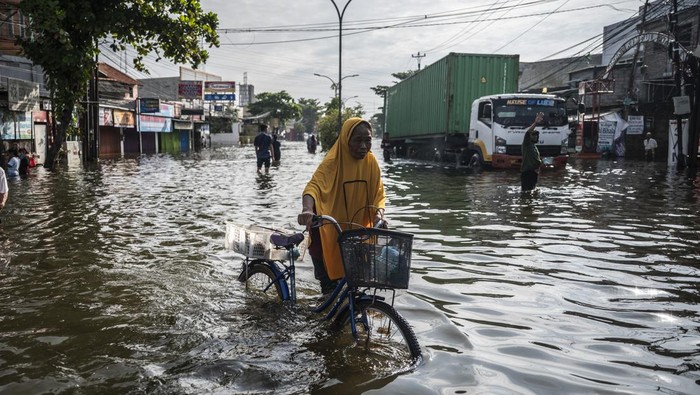 Sejumlah warga berjalan menembus banjir di Jalan Kaligawe Raya, Semarang, Jawa Tengah, Rabu (29/10/2025). Menurut data sementara BPBD Kota Semarang sebanyak 39.405 jiwa dari 29.772 KK di 18 wilayah terdampak banjir yang melanda Kota Semarang akibat dari anomali cuaca dengan intensitas hujan tinggi sejak Selasa (21/10). ANTARA FOTO/Aprillio Akbar/nz