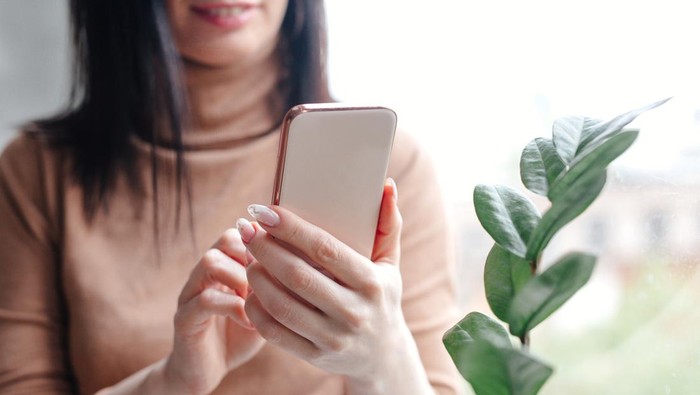 Close up young woman looking at smartphone for video online chat with friends or surf the internet or playing mobile application in relax time