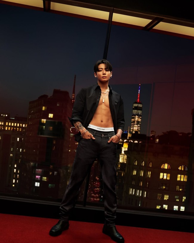 Dengan latar kota New York, Jungkook BTS menampilkan aura rockstar dalam balutan kemeja hitam Calvin Klein yang tidak dikancingkan, mengekspos dada dan otot perutnya. Foto: dok. Calvin Klein