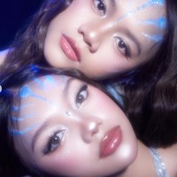 Kedua kakak beradik ini tampil dengan riasan wajah dari MUA @mimi.mua.mua. Sentuhan garis biru di dahi dan pipi menyerupai pola khas bangsa Na’vi dalam film Avatar. Highlight berkilau di pipi dan kelopak mata memberi kesan, seolah kulit mereka bercahaya. Foto: Instagram/@naura.ayu