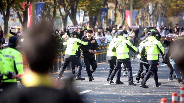 Polisi Hentikan Aksi Pengunjuk Rasa Berlari ke Lokasi Kunjungan Trump di Gyeongju Di kota Gyeongju, Korea Selatan, pada Rabu (29/10/2025), bentrokan pemantauan mewarnai kunjungan resmi Donald Trump dalam rangka KTT APEC 2025. Ratusan pengunjuk rasa menentang kedatangan Presiden AS itu berupaya berlari menuju lokasi pertemuan puncak, namun dihentikan oleh barikade polisi yang berjaga ketat di sekitar venue. REUTERS/Yonhap