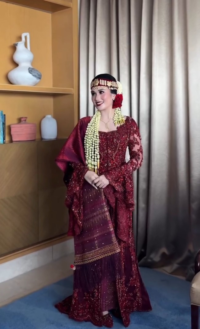 Magisha tampil cantik dengan riasan wajah bold khas pengantin Batak. Matanya dipulas eyeshadow nuansa cokelat gelap, sementara bibir menggunakan lipstik merah terang. Foto: Instagram/@merdisihombingluxury @myrnamyura
