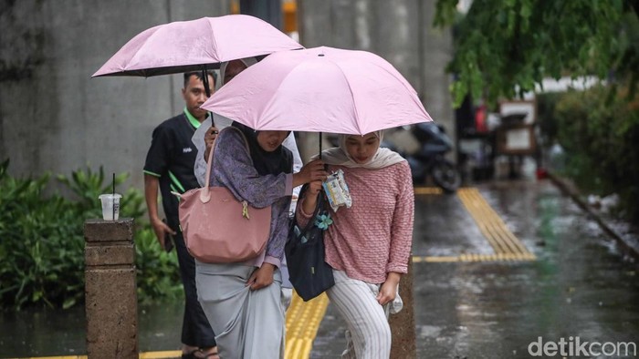 Hujan Dicemari Mikroplastik, Warga Jakarta Diimbau Pakai Masker Sejumlah warga menerobos hujan di kawasan Cawang, Jakarta Timur, Kamis (30/10/2025). Ancaman mikroplastik turun bersama tetesan air hujan di Jakarta. Fenomena ini jadi alarm serius bagi lingkungan perkotaan dan warga diimbau pakai masker.