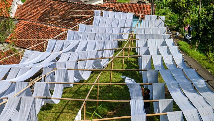 Produksi Kain Pel di Bandung Turun Saat Musim Hujan Pekerja mengeringkan kain untuk dijadikan kain pel di Desa Laksana, Kecamatan Ibun, Kabupaten Bandung, Jawa Barat, Kamis (30/10/2025). Pekerja menyebutkan pada musim penghujan, produksi kain pel yang dijual dengan harga Rp50.000 per kodi tersebut mengalami penurunan hingga 50 persen atau hanya mampu memproduksi 150 kodi per minggu dibandingkan dengan musim kemarau yang mampu menembus hingga 300 kodi per minggu. ANTARA FOTO/Raisan Al Farisi/rwa.