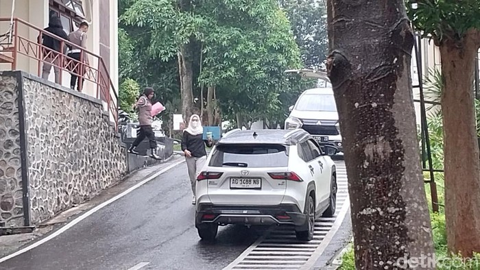 SNR menuju mobil putih diikuti oleh dua petugaa kepolisian berseragam lengkap SNR menuju mobil putih diikuti oleh dua petugaa kepolisian berseragam lengkap