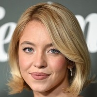 Rambut bob pendek ditata sedikit bervolume dengan efek glossy, sementara wajahnya dipulas makeup bernuansa rosy yang memberi kesan segar sekaligus romantis. Foto: Variety via Getty Images/Gilbert Flores