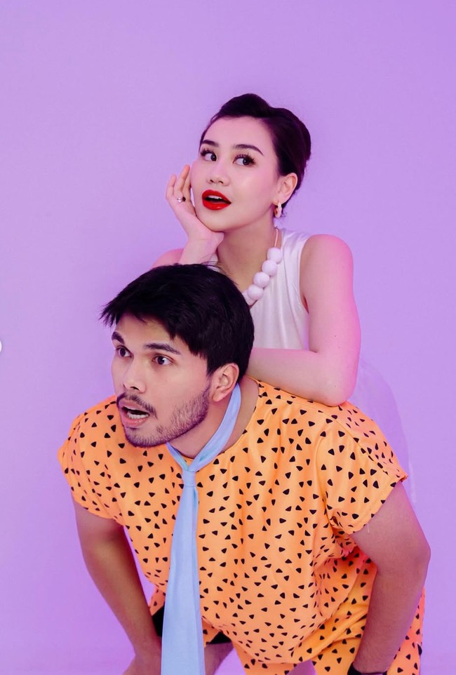 Thariq mengenakan rompi oranye bermotif dengan dasi biru muda seperti karakter Fred. Sementara Aaliyah memerankan karakter Wilma dengan elegan lewat gaun putih sederhana tanpa lengan dan kalung manik besar berwarna putih. Foto: Instagram/@thariqhalilintar