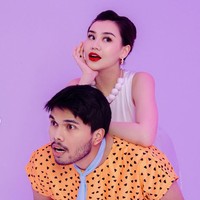 Thariq mengenakan rompi oranye bermotif dengan dasi biru muda seperti karakter Fred. Sementara Aaliyah memerankan karakter Wilma dengan elegan lewat gaun putih sederhana tanpa lengan dan kalung manik besar berwarna putih. Foto: Instagram/@thariqhalilintar