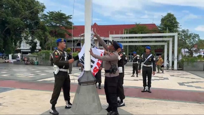 Aparat menurunkan bendera Aliansi Masyarakat Pati Bersatu di Alun-alun Pati, Jumat (31/10/2025). Aparat menurunkan bendera Aliansi Masyarakat Pati Bersatu di Alun-alun Pati, Jumat (31/10/2025).