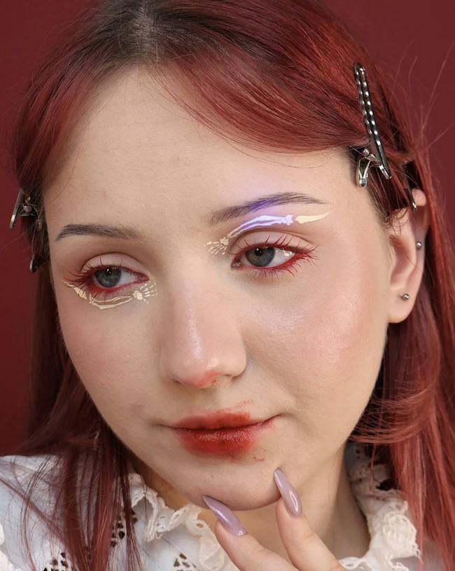 Skeleton Kreaktor konten asal Ukraina, Roni, memadukan unsur Halloween namun tetap cantik lewat motif kerangka di bawah dan atas mata. Roni juga membuat garis mata warna merah, maskara merah, dan lipstik warna senada, namun pulaskan sedikit berantakan untuk efek dramatis. Foto: dok. Instagram