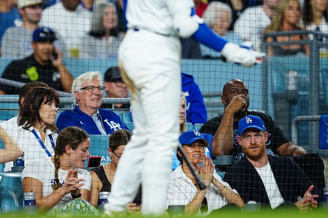 Ia menambahkan, Meghan tampak menggunakan alas bedak yang lebih berat untuk hasil akhir yang merata, serta blush on dan bronzer untuk memberi definisi pada wajah. “Riasan matanya sedikit lebih kuat dari biasanya, namun tetap lembut di bawah topi dan pencahayaan stadion,” katanya. (Foto: Mary DeCicco/MLB Photos via Getty Images)