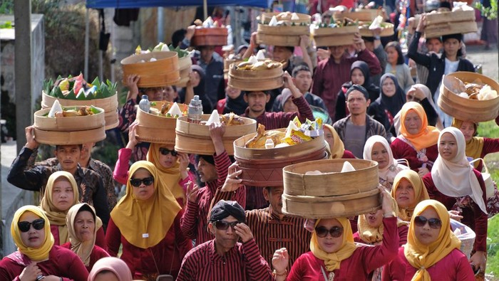 Sejumlah warga mengusung tenong berisi berbagai jenis makanan saat tradisi Merti Desa di kawasan Lembah  Sindoro-Sumbing Desa Kledung, Temanggung, Jawa Tengah, Jumat  (31/10/2025). Tradisi turun temurun rutin dilaksanakan masyarakat petani setempat dengan kirab, doa bersama, penanaman pohon dan kenduri sebagai ungkapan rasa syukur kepada Tuhan atas kemakmuran dan kesejahteraan sekaligus wujud pelestarian lingkungan hutan dan mata air. ANTARA FOTO/Anis Efizudin/foc.