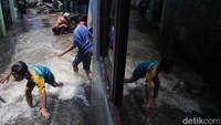 Sejumlah anak terlihat bermain di tengah genangan banjir di Jati Padang. 