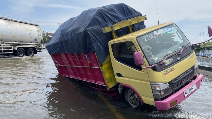 Truk nyungsep masuk lubang di tengah banjir di Jalan Kaligawe Pantura Semarang-Demak, Kecamatan Genuk, Kota Semarang, Jumat (31/10/2025).