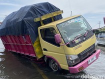 Truk Nyaris Terguling Usai Terperosok Lubang Tertutup Banjir di Kaligawe