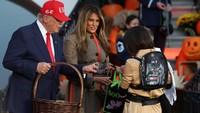 Trump dan Melania membagikan cokelat dalam kotak berlogo kepresidenan kepada para tamu kecil. REUTERS/Kylie Cooper  Trump dan Melania membagikan cokelat dalam kotak berlogo kepresidenan kepada para tamu kecil. REUTERS/Kylie Cooper