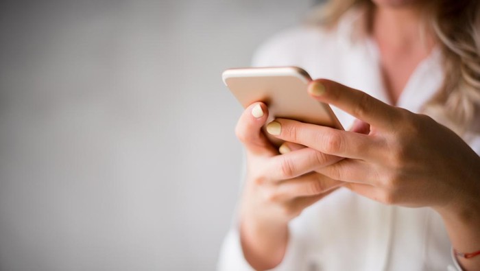 Close up of a woman using her smartphone indoors.