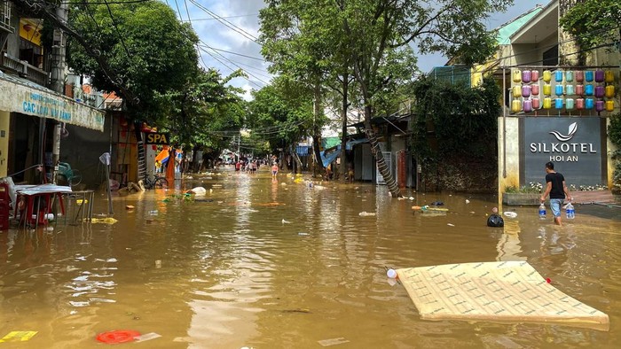 People wade through a flooded street in Hoi An, following deadly floods in central Vietnam, October 31, 2025. REUTERS/Thinh Nguyen
