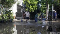 Warga membersihkan sisa lumpur dan genangan air di kawasan Pondok Kacang Permai, Tangerang Selatan, Sabtu (1/11/2025), setelah banjir akibat tanggul jebol semalam.