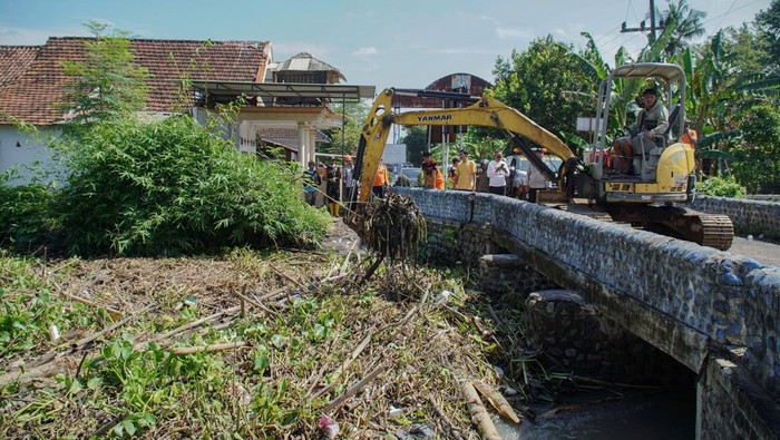 Penanganan dan bantuan untuk korban banjir di Lumajang Petugas menggunakan alat berat mengangkut sampah yang menyumbat aliran sungai sehingga menyebabkan banjir di Rowokangkung, Lumajang, Jawa Timur, Sabtu (1/11/2025). Pemkab Lumajang memberikan bantuan air bersih dan makanan siap saji untuk korban banjir serta melakukan normalisasi sejumlah sungai karena luapan airnya telah menyebabkan 895 rumah warga tergenang banjir di wilayah tersebut. ANTARA FOTO/Irfan Sumanjaya/tom.