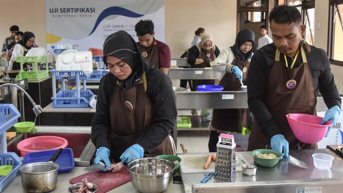 Sejumlah juru masak mengikuti pelatihan peningkatan kompetensi kuliner di Ruang Praktik Tata Boga SMK Negeri 1 Ciamis, Jawa Barat, Minggu (2/11/2025). Pelatihan yang digelar LPK Gemilang Cita Nusantara bekerja sama dengan LSP Mutu Wisata dan Badan Nasional Sertifikasi Profesi (BNSP) itu diikuti oleh 18 peserta dari dapur SPPG MBG Ciamis untuk meningkatkan keterampilan dan mendapatkan sertifikasi profesi tenaga kerja kuliner. ANTARA FOTO/Adeng Bustomi