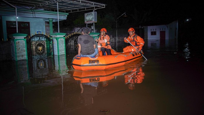 Petugas BPBD Lumajang mengevakuasi warga terdampak banjir dengan menggunakan perahu di Desa Kutorenon, Kecamatan Sukodono, Lumajang, Jawa Timur, Minggu (2/11/2025). Badan Penanggulangan Bencana Daerah (BPBD) Lumajang mengevakuasi dan menyalurkan bantuan logistik bagi warga terdampak banjir berketinggian air 80 hingga 150 centimeter tersebut menyusul hujan deras disertai angin kencang di wilayah itu. ANTARA FOTO/Irfan Sumanjaya