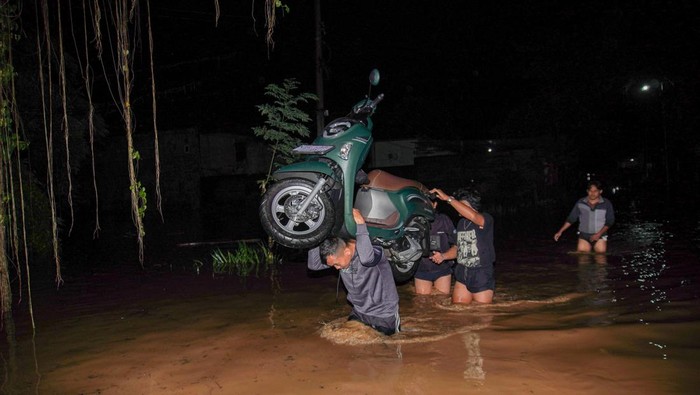 Petugas BPBD Lumajang mengevakuasi warga terdampak banjir dengan menggunakan perahu di Desa Kutorenon, Kecamatan Sukodono, Lumajang, Jawa Timur, Minggu (2/11/2025). Badan Penanggulangan Bencana Daerah (BPBD) Lumajang mengevakuasi dan menyalurkan bantuan logistik bagi warga terdampak banjir berketinggian air 80 hingga 150 centimeter tersebut menyusul hujan deras disertai angin kencang di wilayah itu. ANTARA FOTO/Irfan Sumanjaya