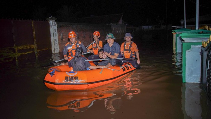 Petugas BPBD Lumajang mengevakuasi warga terdampak banjir dengan menggunakan perahu di Desa Kutorenon, Kecamatan Sukodono, Lumajang, Jawa Timur, Minggu (2/11/2025). Badan Penanggulangan Bencana Daerah (BPBD) Lumajang mengevakuasi dan menyalurkan bantuan logistik bagi warga terdampak banjir berketinggian air 80 hingga 150 centimeter tersebut menyusul hujan deras disertai angin kencang di wilayah itu. ANTARA FOTO/Irfan Sumanjaya