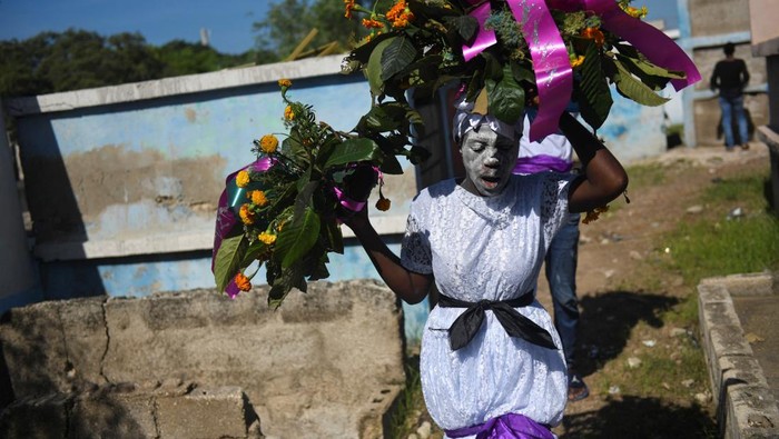 Penganut kepercayaan Voodoo di Haiti menggelar perayaan Hari Orang Mati di pemakaman Kagouye, kawasan Meyotte, Port-au-Prince, Sabtu (1/11/2025). Suasana penuh warna dan ritual mistis tampak mewarnai peringatan tahunan ini. REUTERS/Johnson Sabin