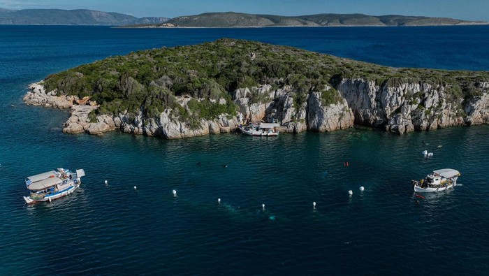 Volunteer divers from the environmental group Aegean Rebreath carry a fish-farming net during an underwater cleanup off the islet of Sapientza, near Methoni, in southern Greece, October 12, 2025. REUTERS/Stelios Misinas