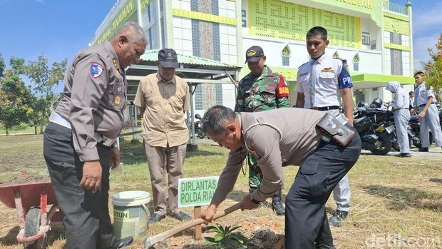 Dirlantas saat tanam pohon bareng siswa, guru dan alumni di SMK Taruna Satria. (Foto: Raja Adil Siregar/detikSumut).