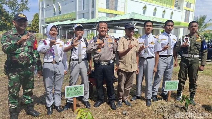 Dirlantas saat tanam pohon bareng siswa, guru dan alumni di SMK Taruna Satria. (Foto: Raja Adil Siregar/detikSumut).