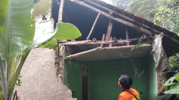 Foto: Petugas BPBD mengecek tembok rumah warga jebol imbas hujan deras disertai angin kencang di Leuwisadeng, Bogor (dok. BPBD Bogor)