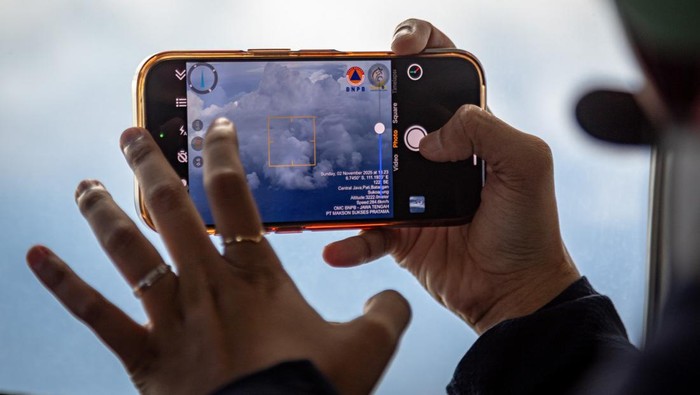 Seorang ilmuwan penerbangan mendokumentasikan kondisi awan sebagai bahan laporan pelaksanaan Operasi Modifikasi Cuaca (OMC) menggunakan pesawat Cessna 208 Caravan PK-SNM BNPB di sekitar wilayah udara pesisir utara Kabupaten Pati, Jawa Tengah, Minggu (2/11/2025). Hingga hari kesembilan atau per Minggu (2/11) penerbangan kedua, BNPB bersama Badan Meteorologi Klimatologi dan Geofisika (BMKG) menghabiskan sebanyak 31 ton NaCl dan 14 ton CaO untuk OMC Jateng dalam rangka penanganan dan mitigasi bencana hidrometeorologi basah di wilayah Kota Semarang dan sekitarnya. ANTARA FOTO/Aji Styawan/rwa.
