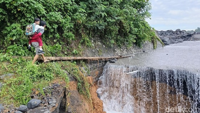 Ortu gendong anak ke sekolah lewat lahar Gunung Semeru