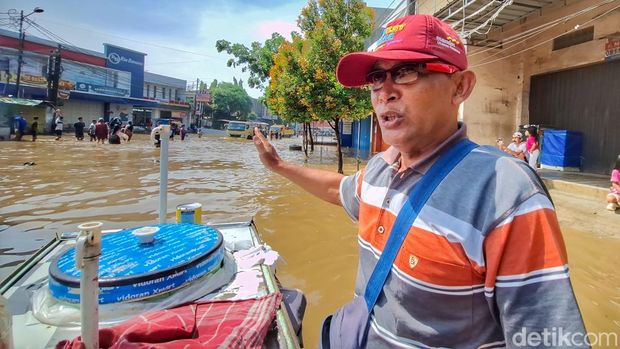 Syarifulloh (57), seorang pedagang es doger kala melintas Jalan Raya Dayeuhkolot, Kabupaten Bandung, Senin (3/11/2025).