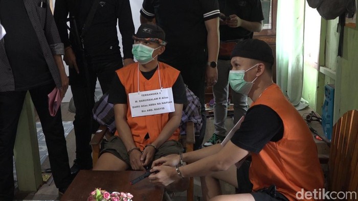 Tersangka kakak beradik, Ahmad Faizal dan Darussalam memperagakan adegan merencanakan penembakan di Polman.