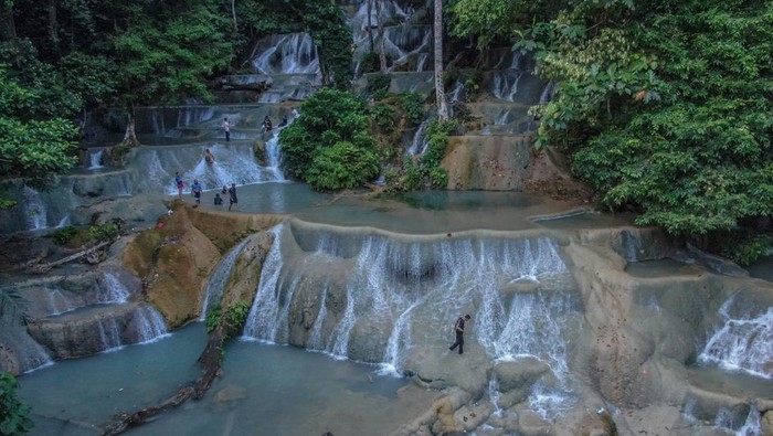 Sejumlah pengunjung berwisata di air terjun Moramo, Desa Sumber Sari, Kecamatan Moramo, Kabupaten Konawe Selatan, Sulawesi Tenggara, Minggu (2/11/2025). Air terjun di kawasan Hutan Suaka Alam Tanjung Peropa, Sulawesi Tenggara tersebut menyuguhkan keindahan tujuh undakan utama dan 60 undakan kecil yang pada tahun 2022 meraih peringkat ketiga kategori daya tarik pengunjung dalam Anugerah Desa Wisata Indonesia. ANTARA FOTO/Andry Denisah/rwa.