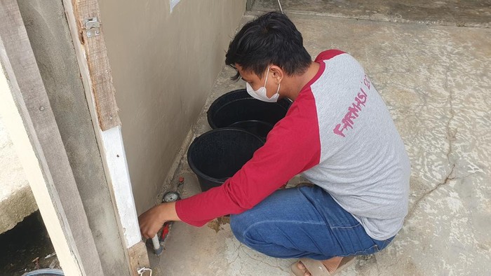 Warga melihat meteran air TSM yang padam sejak beberapa hari lalu.