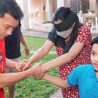 Masih mengenakan daster, Ashanty yang matanya ditutup kain tampak digandeng oleh suaminya, Anang Hermansyah, dan putra mereka, Arsy. Foto: Instagram/@ashanty_ash