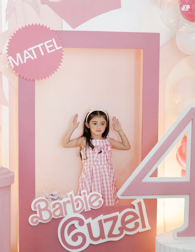 Tampil simpel, Guzel terlihat cantik mengenakan dress kotak-kotak pink tanpa lengan. Rambut panjangnya dibiarkan terurai dengan dihiasi bando senada. Foto: Instagram/@marginw