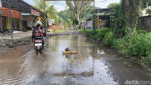Warga Lingkungan Menang, Kelurahan Gerung Selatan, Kecamatan Gerung, Lombok Barat, pasang pelang minta bibit ikan di jalan yang tergenang air.