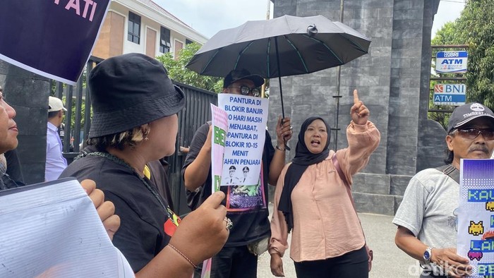 Masyarakat Pati menuntut pembebasan Teguh dan Supriyono di halaman Mapolda Jateng, Kota Semarang, Selasa (4/11/2025).