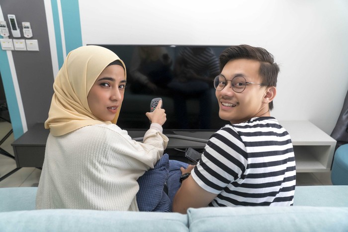 Pasangan muslim menonton TV di rumah