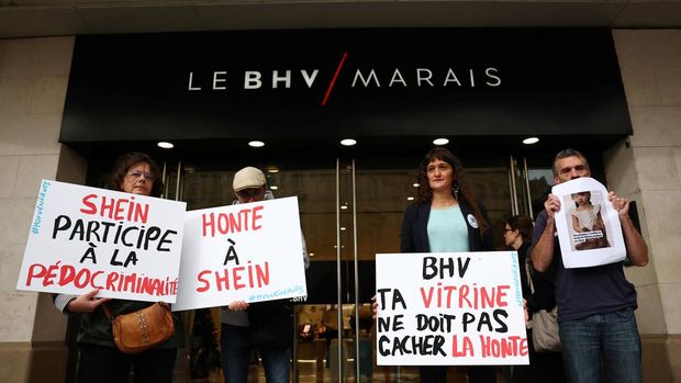 Orang-orang memprotes penjualan boneka seks anak-anak oleh peritel fesyen cepat China, Shein, dalam sebuah konferensi di depan Bazar de l'Hotel de Ville, pusat perdagangan Le BHV Marais, menjelang pembukaan toko permanen pertama Shein di Paris, Prancis, 3 November 2025. Slogan-slogan pada plakat antara lain 