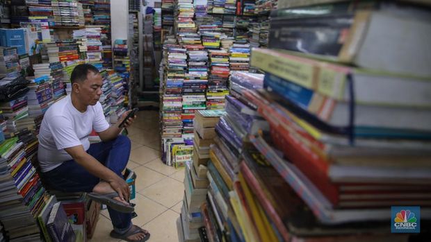 Pedagang buku menunggu pembeli di Sentra Toko Buku Kwitang, Jakarta, Selasa (4/11/2025). Sentra toko buku Kwitang masih cukup eksis meski kondisinya tak seramai dahulu ditengah gempuran marketplace. (CNBC Indonesia/Faisal Rahman)