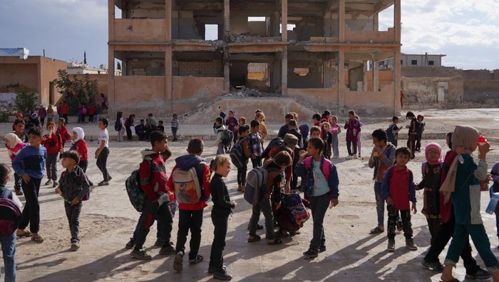 Students gather in the yard of a damaged school in Idlib countryside, Syria, October 9, 2025. REUTERS/Karam al-Masri