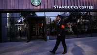 Seorang penjaga keamanan berjalan melewati kedai kopi Starbucks di Beijing, Cina, Selasa (4/11/2025). REUTERS/Tingshu Wang