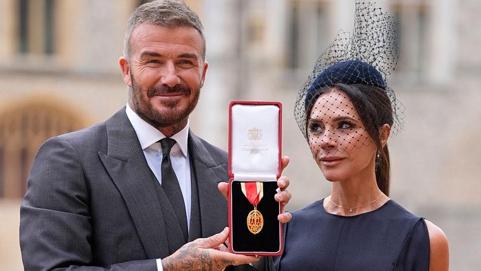 WINDSOR, ENGLAND - NOVEMBER 4: Sir David Beckham poses with his wife Lady Victoria after he was made a Knight Bachelor at an investiture ceremony at Windsor Castle on November 4, 2025 in Windsor, England. (Photo by Andrew Matthews - Pool/Getty Images)