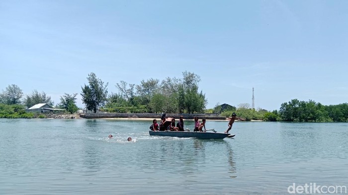 Anak-anak sekolah menyeberangi muara menggunakan di Desa Seriwe, Kecamatan Jerowaru, Lombok Timur, NTB untuk pergi ke sekolah, Rabu (5/11/2025). (Sanusi Ardi W/detikBali)
